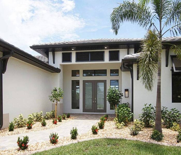 Moderner Neubau in Florida mit Palmen an der Einfahrt und großen Fenstern